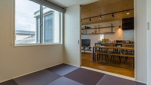 Un intérieur moderne avec une grande fenêtre, un coin repas et une cuisine.