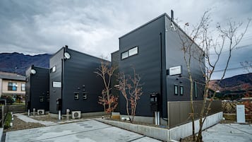 A modern building with a flat roof, a satellite dish, and a sign indicating it is a hotel.