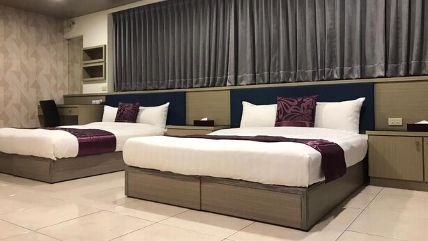 A hotel room with two beds, a large window with curtains, a bedside table, and a built-in shelf. - Rural Area Hotel (Zhuqi)