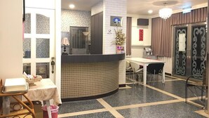 A hotel lobby with a reception desk, a dining area, and a reception counter. - Rural Area Hotel (Zhuqi)