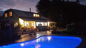 Een huis met een zwembad in de schemering.