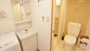 Een kleine badkamer met toilet, wastafel en douche.