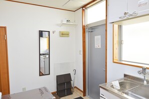 A compact bathroom with a sink, mirror, and a small shelf above the mirror. - Chateau TIIDA 1F (Naha)