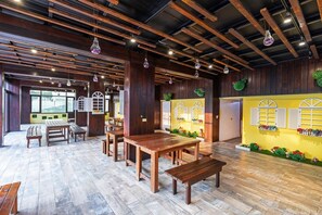 A spacious indoor area with wooden tables and benches, a high ceiling with exposed beams, and decorative windows with shutters. - 17 Happiness (Liuqiu)