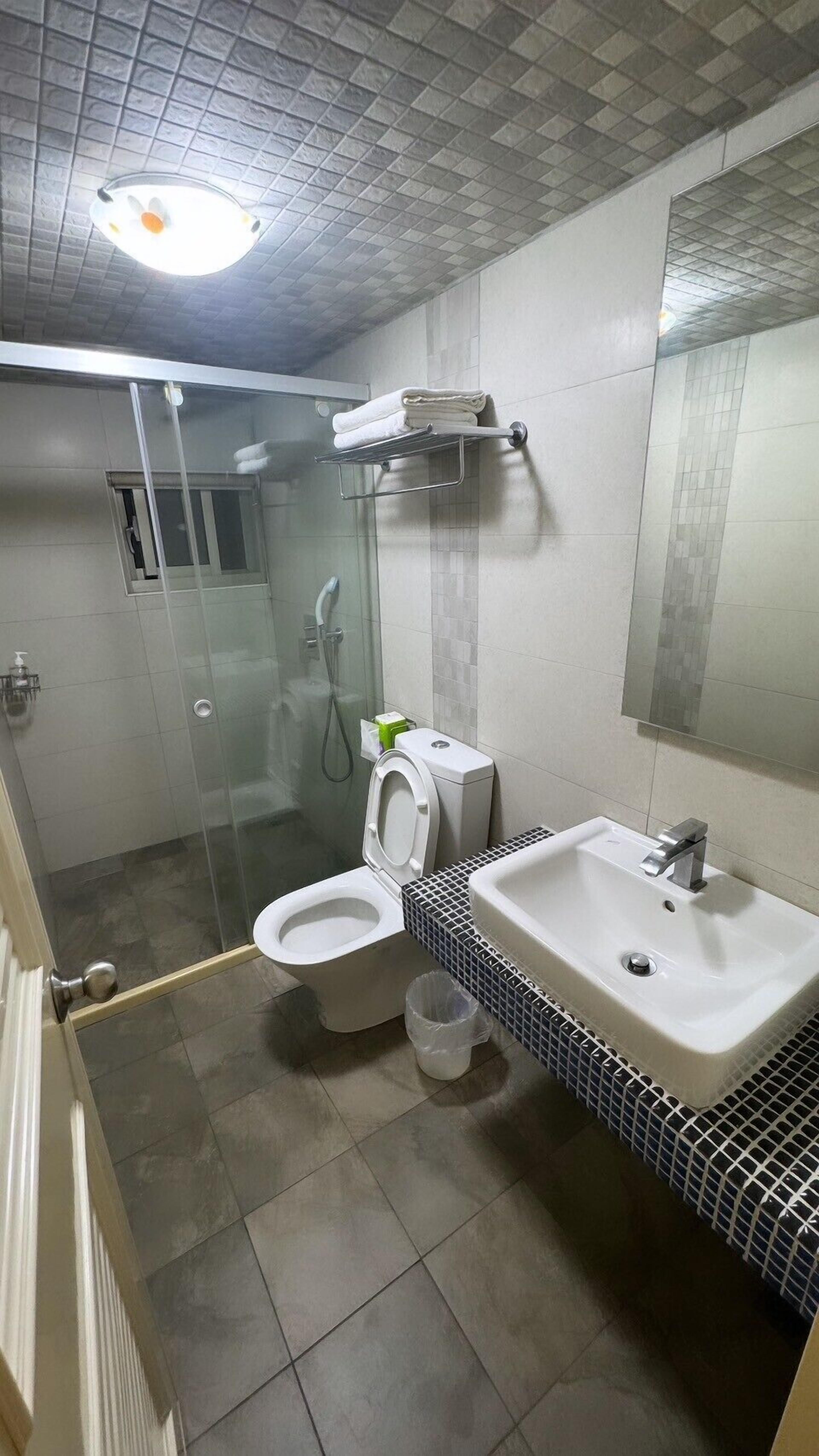 A bathroom with a toilet, sink, and shower.