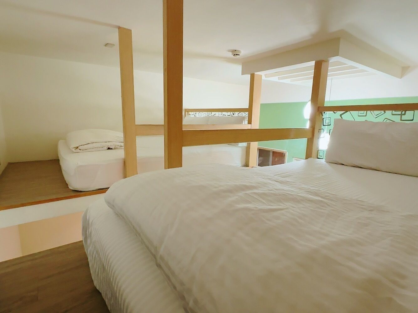 A bedroom with a large bed, a wooden headboard, and a small white chair.