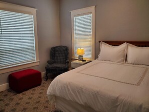 Relax in this inviting space with a comfortable bed, a cozy chair, and a convenient nightstand.