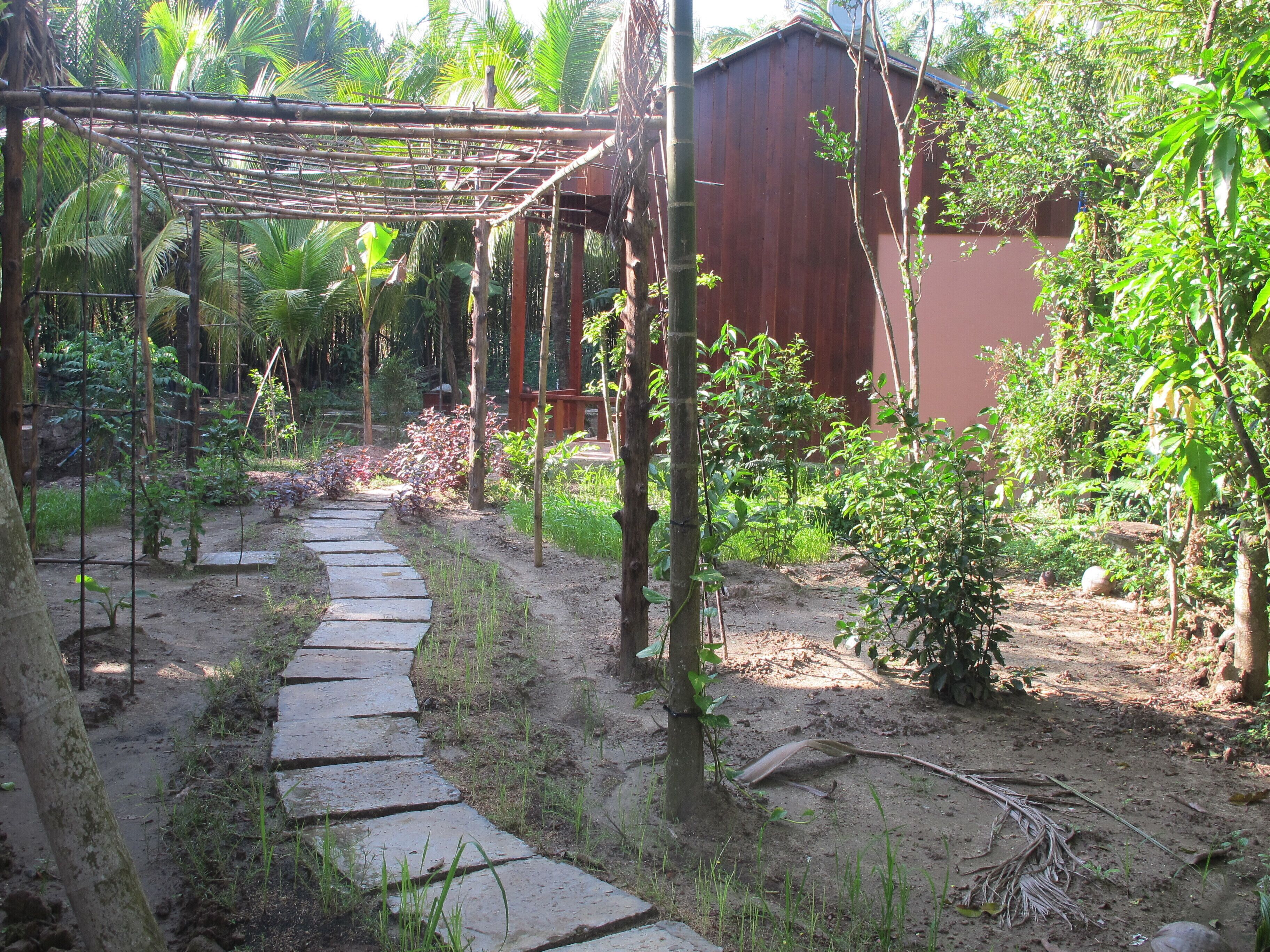 A garden with a stone pathway leading to a wooden structure.