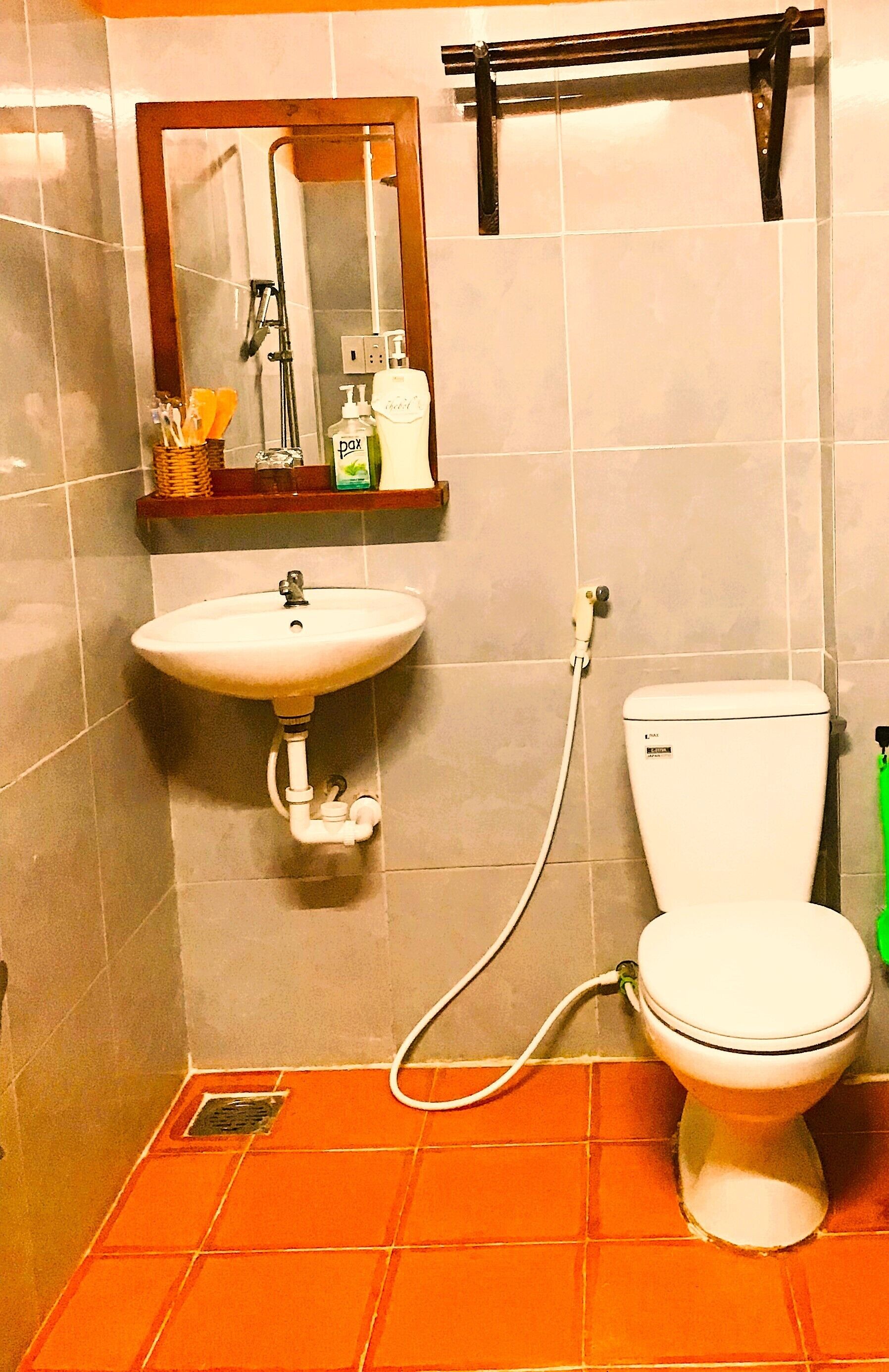 A bathroom with a sink, toilet, and mirror.