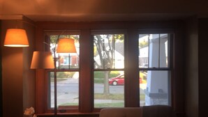 Une pièce avec une fenêtre, une chaise et une lampe.