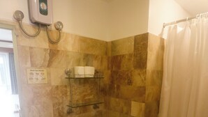 Un baño con inodoro, lavabo, ducha y dispensador de gel antibacterial.
