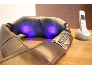 A massage chair with a control panel and a phone charging dock. - Funhouse Katsuragawa (Kyoto)