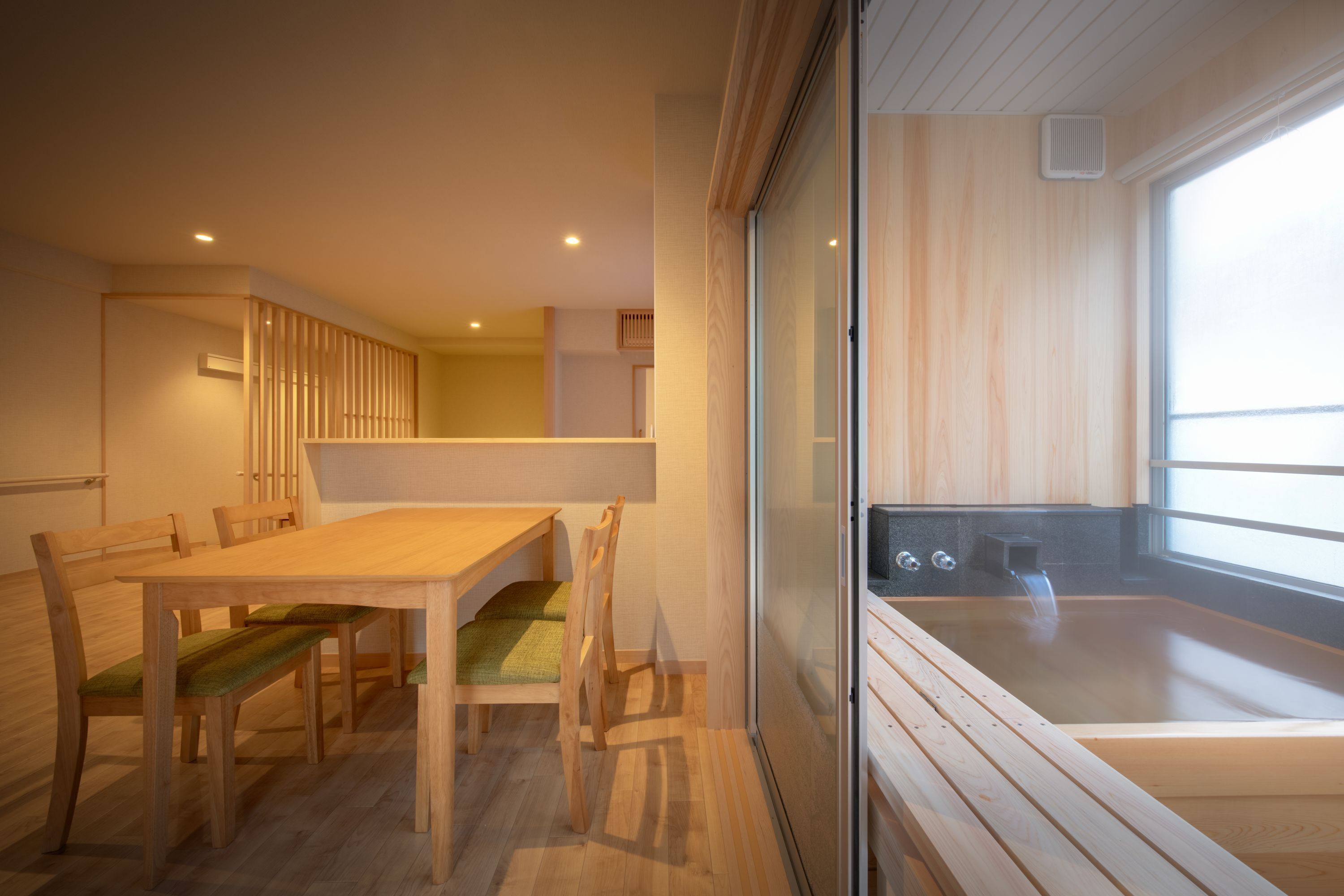 A modern interior with a wooden dining table, chairs, and a large window.