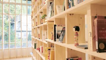 A bookshelf with various books and a small plant.