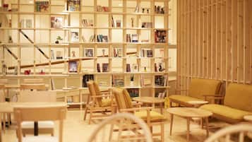 Une bibliothèque avec des étagères, des chaises et des tables.