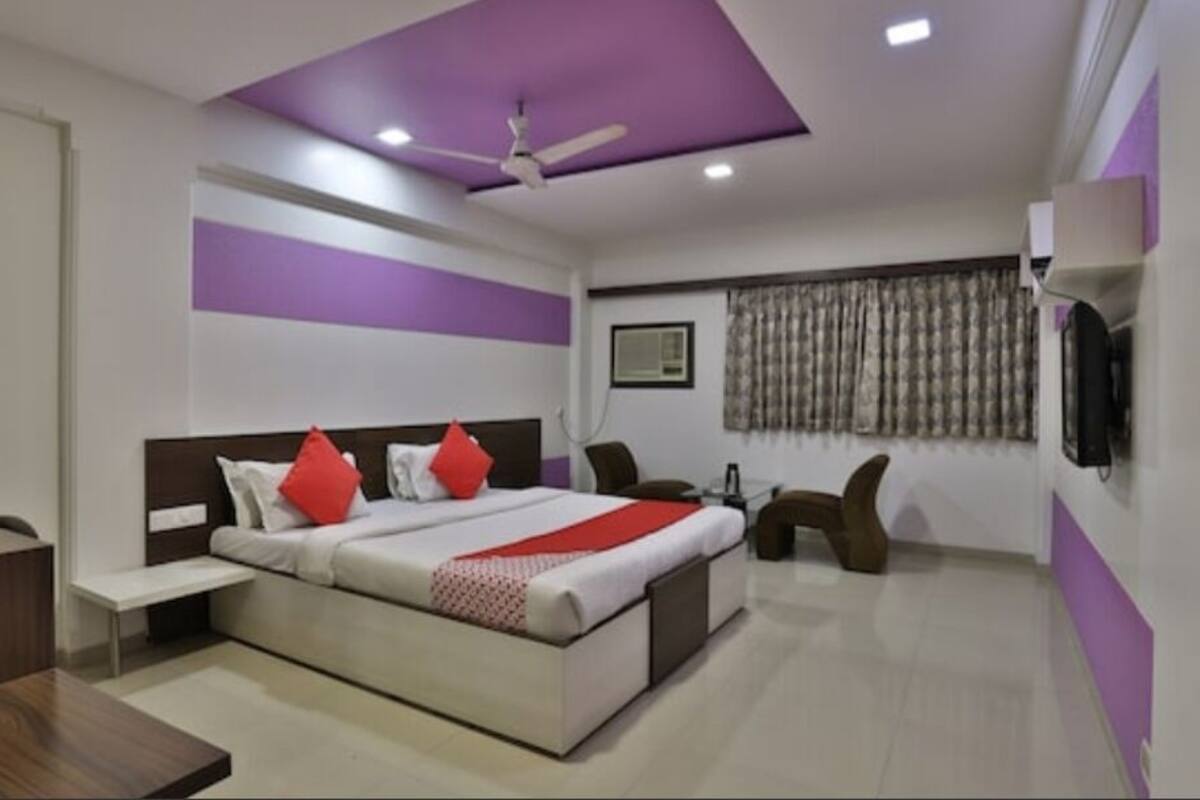 Quarto moderno com cama, mesa de cabeceira e escrivaninha.