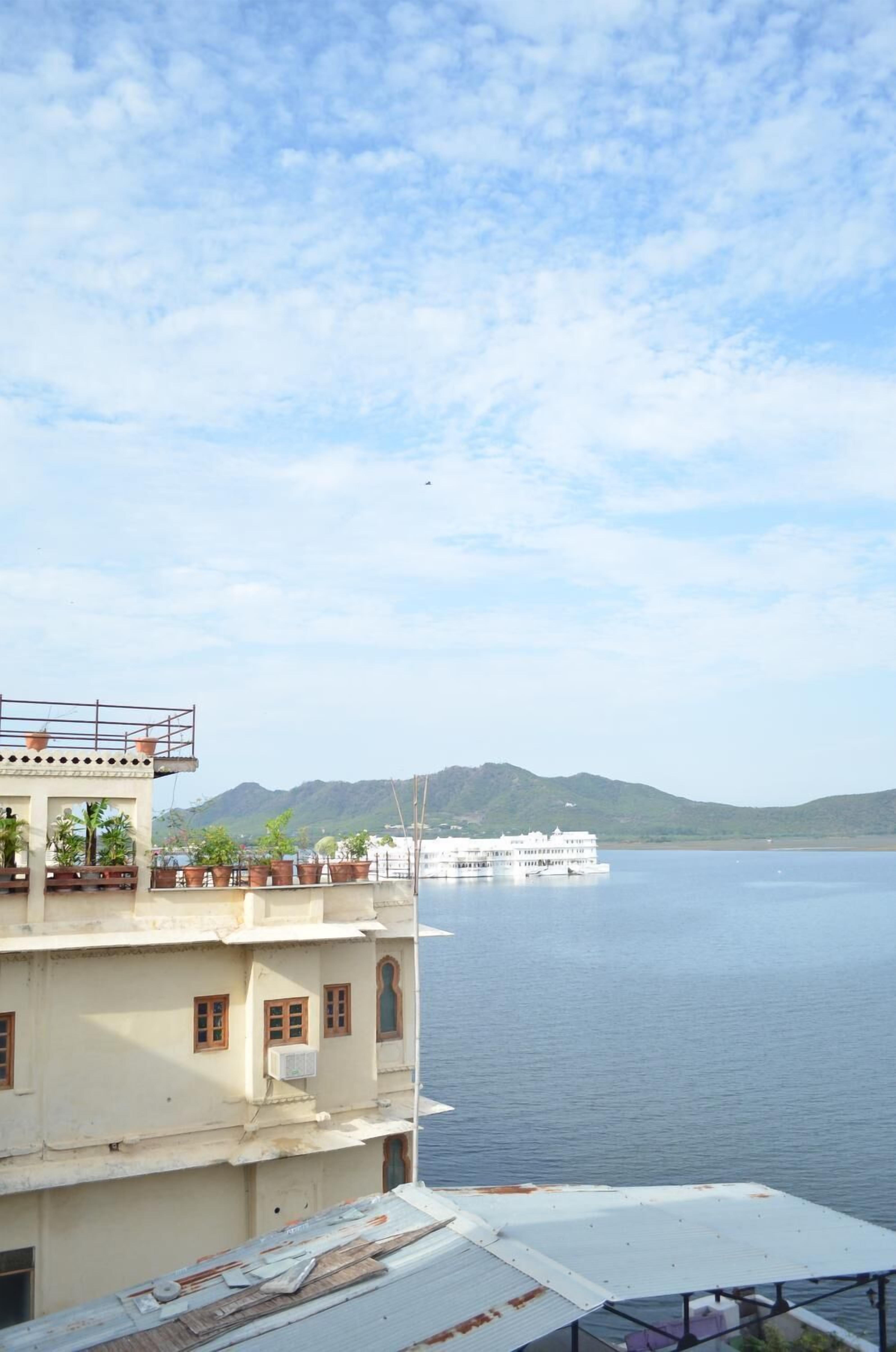 A building with multiple floors and balconies overlooking a large body of water.