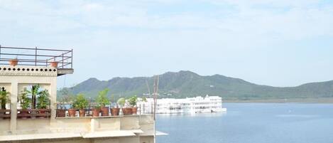 A building with multiple floors and balconies overlooking a large body of water.