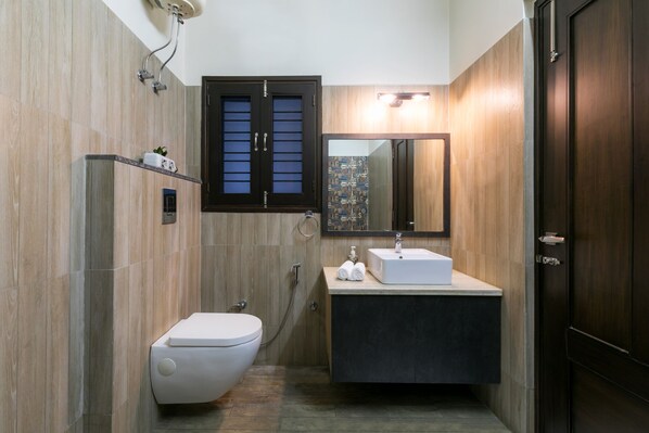 A modern bathroom with a toilet, sink, and mirror.