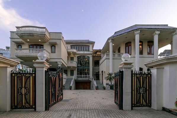 A grand building with multiple floors, large columns, and a central entrance with a staircase.