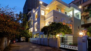 A multi-story building with balconies, a gated entrance, and a well-lit facade. - Ashapura Niwas by Vista Rooms (Jaipur)