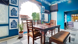 A dining area with a checkered floor, a wooden table, and chairs. - Ashapura Niwas by Vista Rooms (Jaipur)
