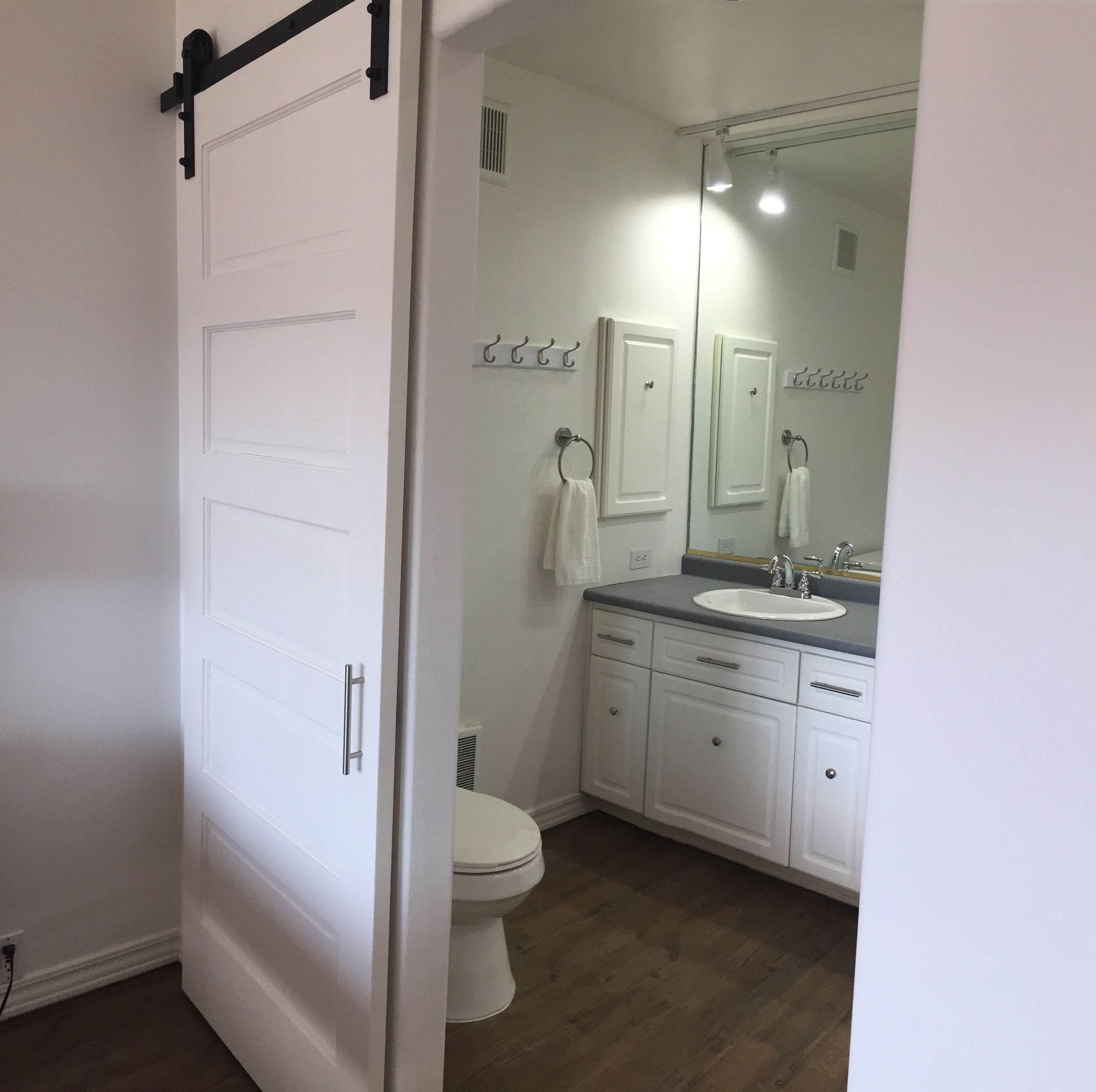 A bathroom with a white toilet, a sink, and a mirror.