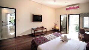A modern hotel room with a bed, a TV mounted on the wall, a desk, a chair, and a balcony with a view. - Purple Cloud Urban (Bengaluru)