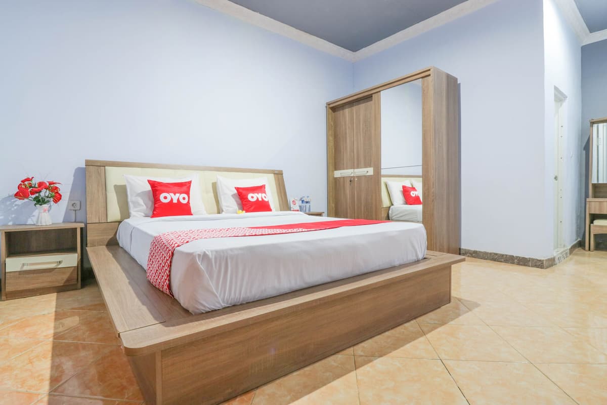 A bedroom with a bed, nightstands, a wardrobe, and a mirror.