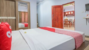 A bedroom with a bed, a wardrobe, and a bathroom. - OYO 1514 Rara Inn (Kuta)