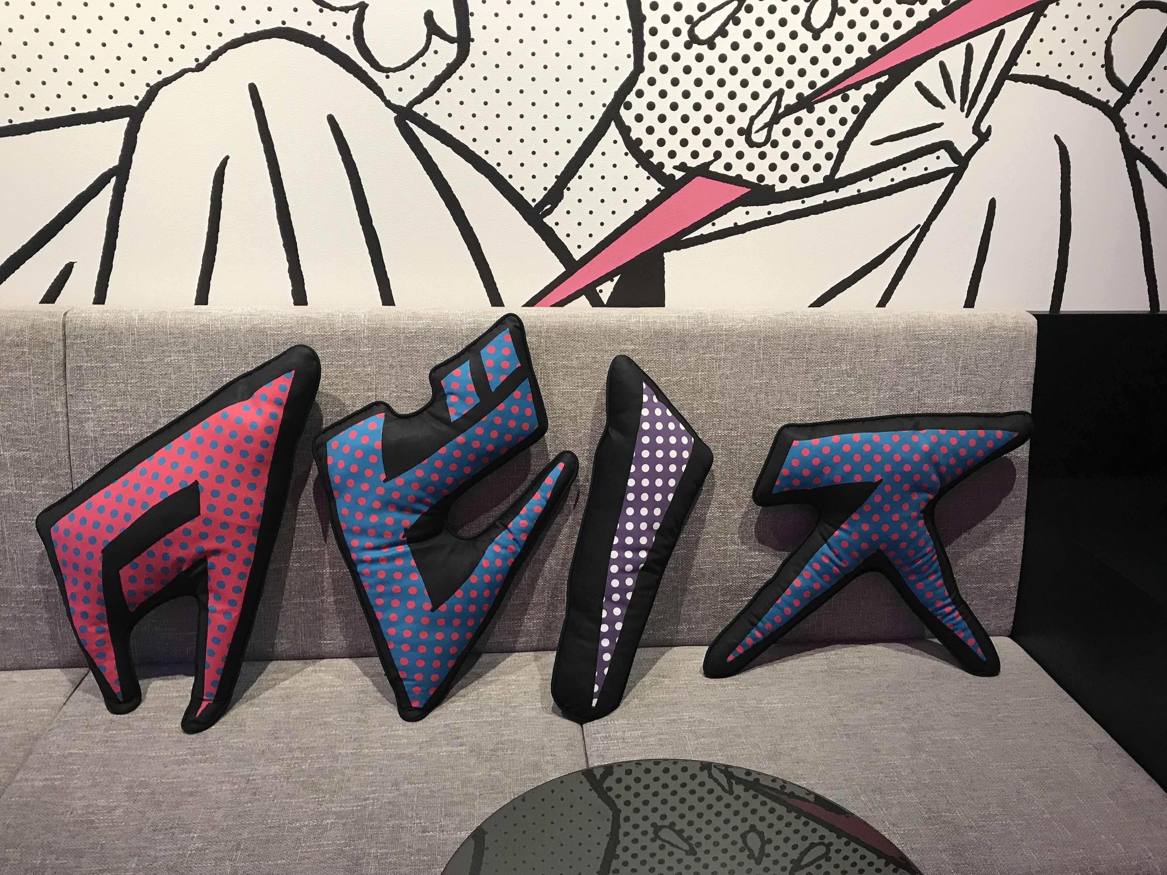 A couch with three pillows featuring geometric patterns.