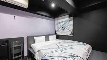 Una camera d'albergo moderna con un letto rifatto, una piccola scrivania e un'opera d'arte appesa al muro.