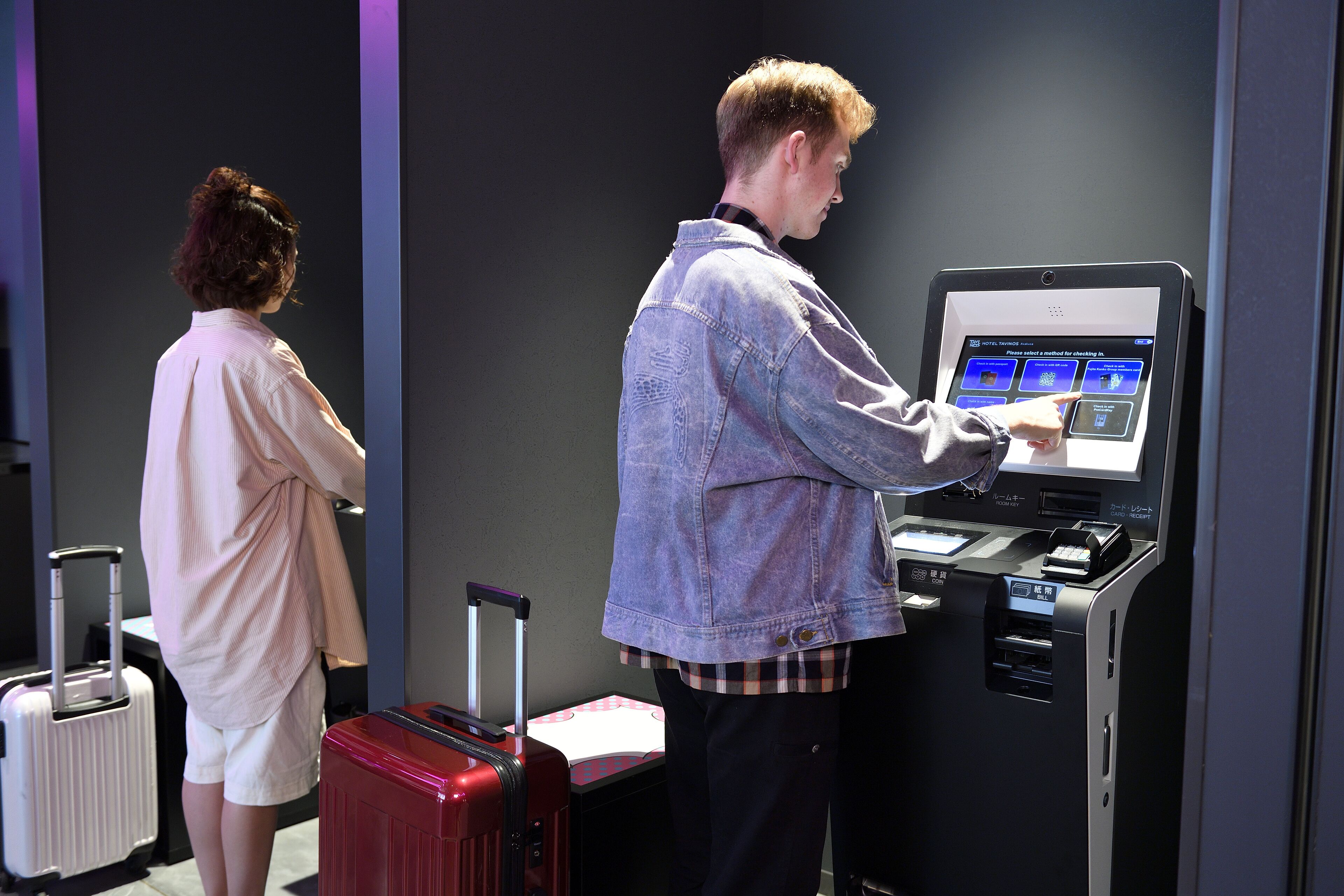 A person using a self-service kiosk in a hotel lobby.
