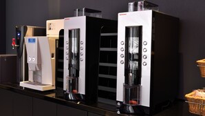 Three coffee machines on a counter with a control panel and a water dispenser. - HOTEL TAVINOS Asakusa (Tokyo)
