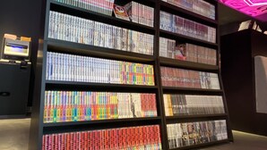 Una amplia estantería iluminada, repleta de libros, ubicada en una habitación de luz tenue y diseño moderno.