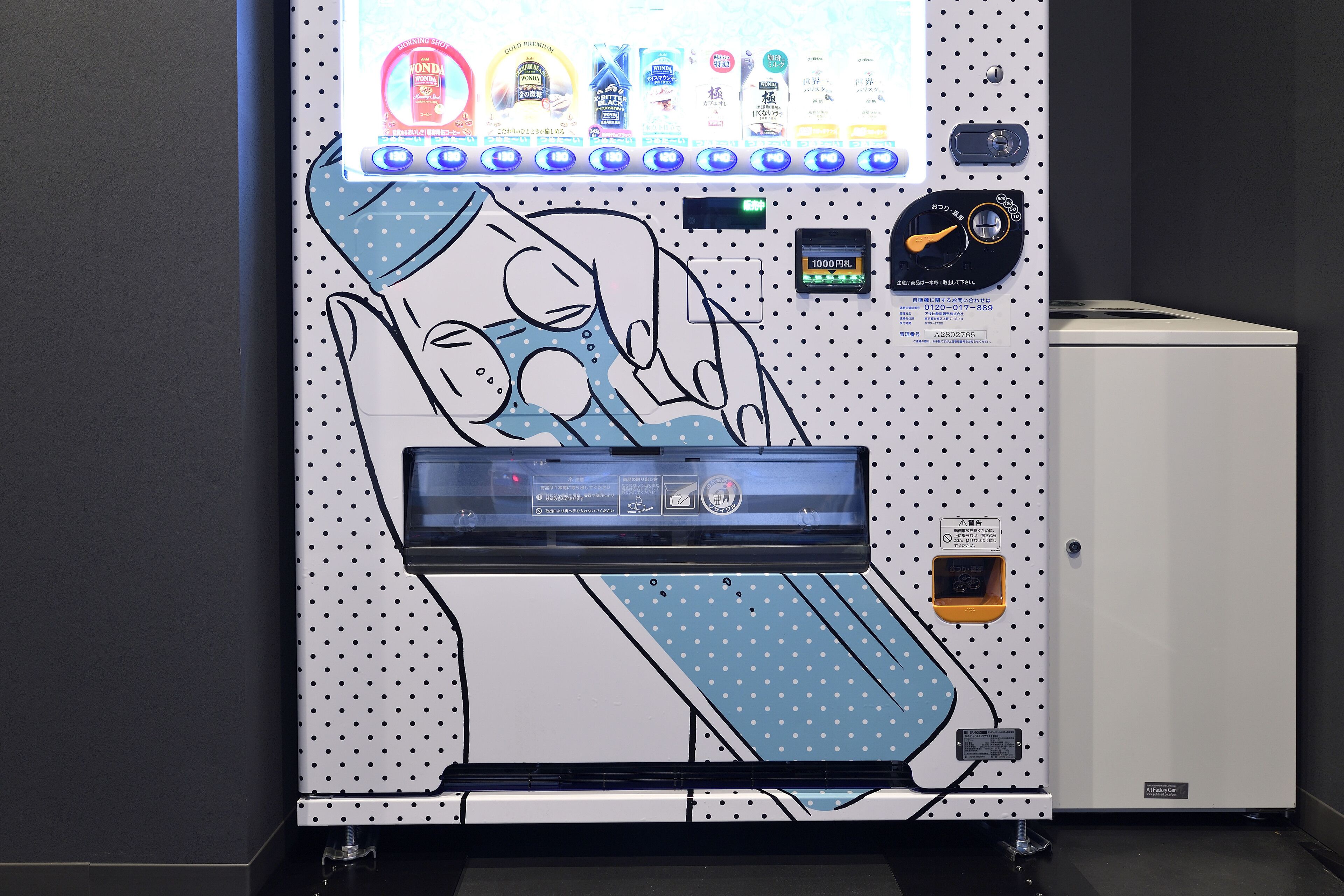 Una habitación con una pantalla digital grande, un panel de control y un mueble pequeño.