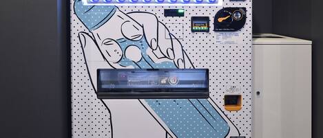 A room with a large digital display, a control panel, and a small cabinet.
