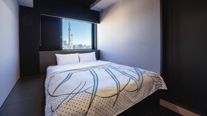 Un dormitorio moderno con una cama grande, vistas a la ciudad y un techo oscuro.