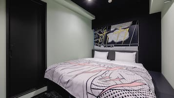 A bedroom with a bed, a dark wardrobe, and a wall with a graphic design.