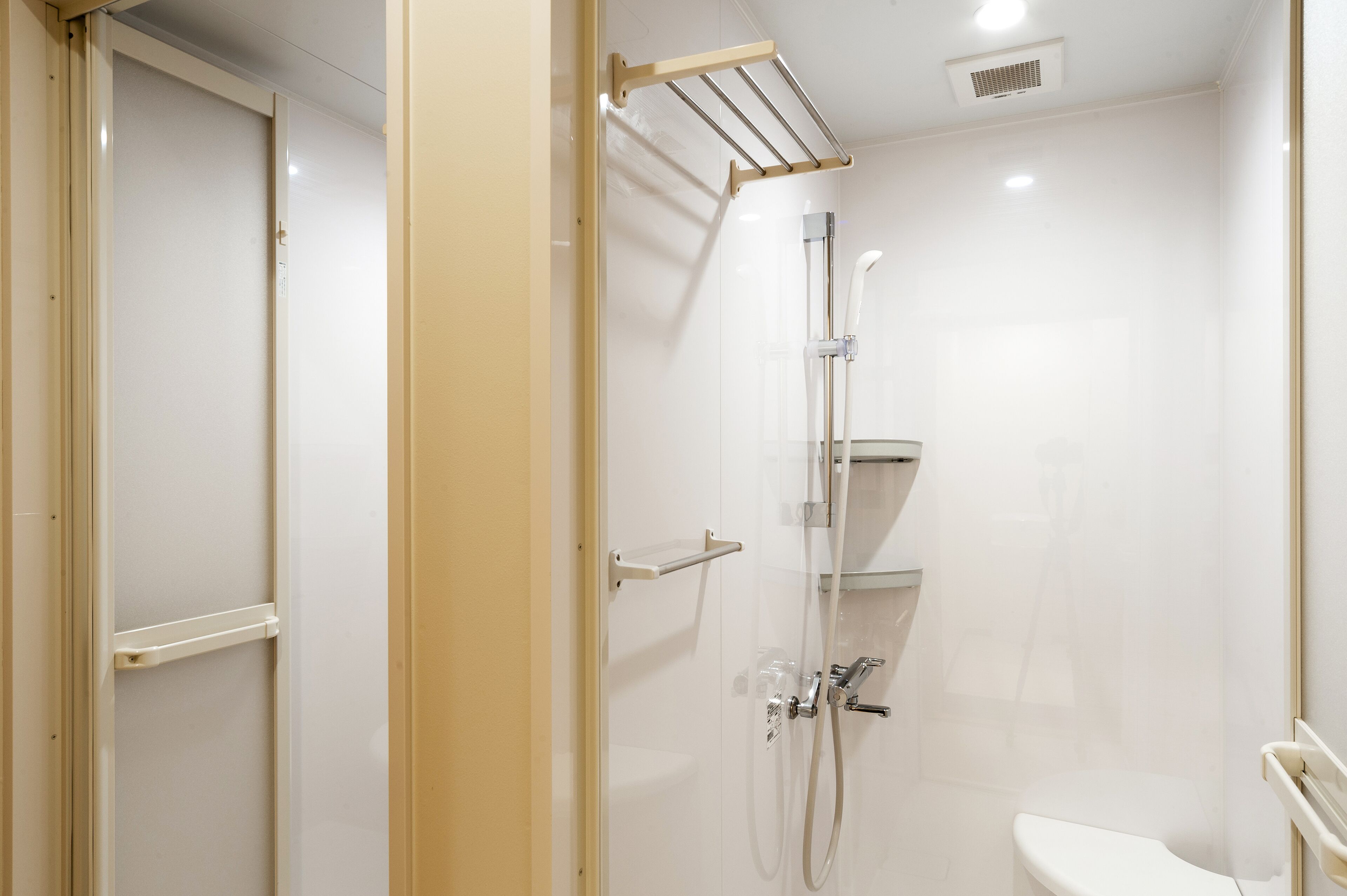 Une salle de bain moderne avec une douche à parois de verre, des toilettes et un porte-serviettes.