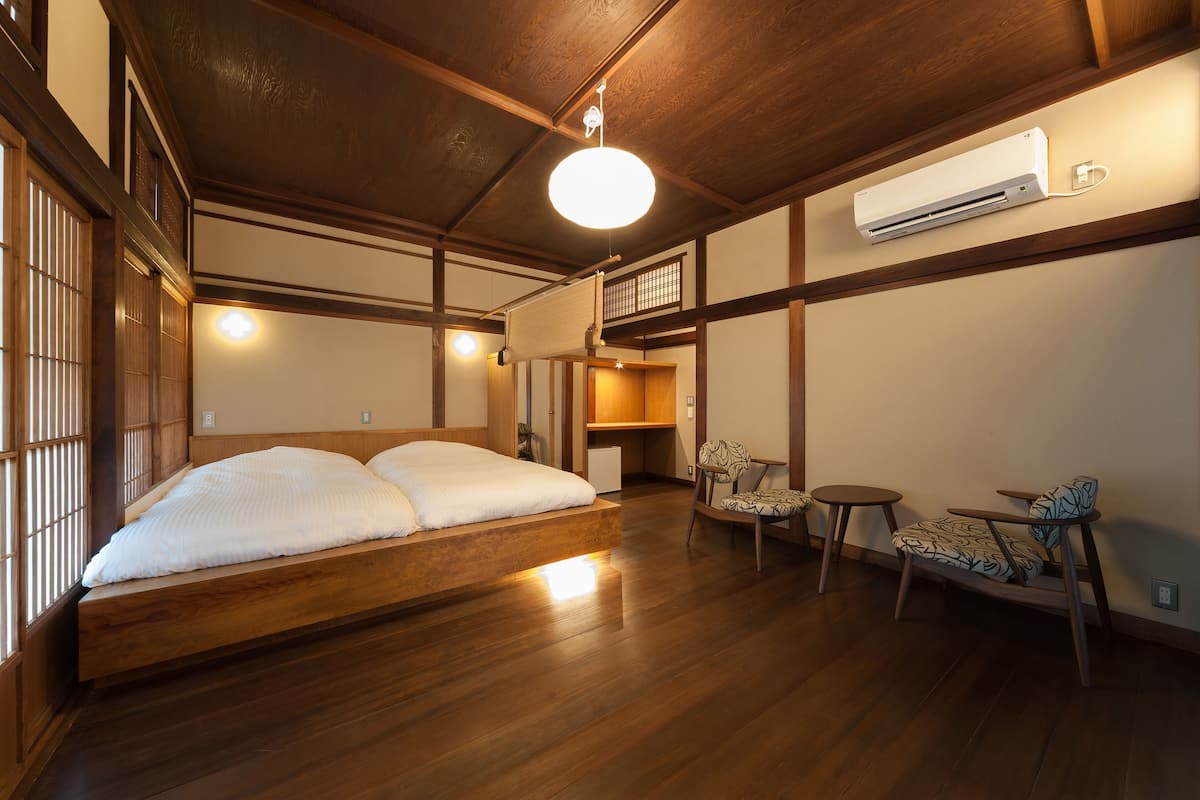 A traditional Japanese-style room with a wooden bed, a desk, and a chair.