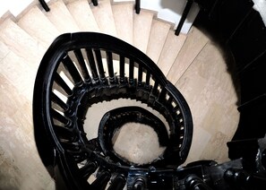 A spiral staircase with a black handrail and beige steps. - Cynarisso Hotel Lagos (Lagos)