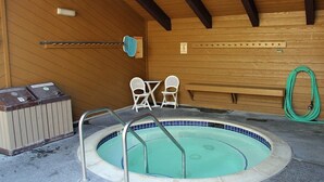 A small indoor pool with a metal ladder, two white chairs, and a wooden bench. - Wildflower 48: Walk to Town & Green Line Shuttle (Mammoth Lakes)