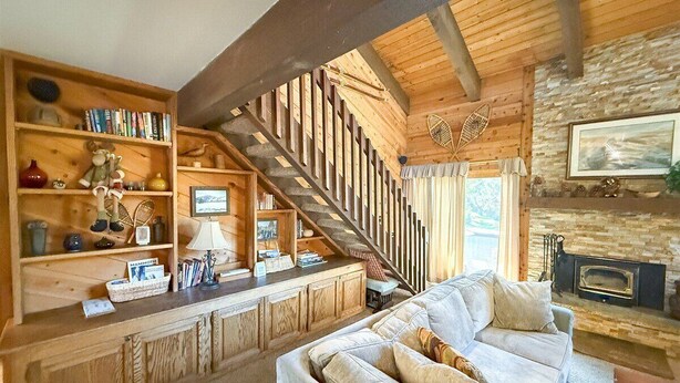 A cozy living room with a wooden staircase, a fireplace, and a comfortable sofa. - Wildflower 48: Walk to Town & Green Line Shuttle (Mammoth Lakes)