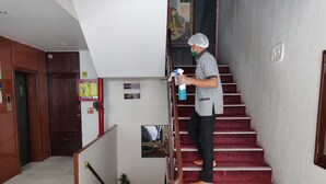 Una persona limpiando una escalera con un pulverizador.