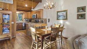 A wooden interior with a dining table, chairs, and a chandelier. - Meadow Ridge: Beautiful Views, Close to Eagle Lodg (Mammoth Lakes)