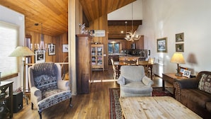 A cozy living room with wooden floors, a fireplace, a dining area, and a kitchen. - Meadow Ridge: Beautiful Views, Close to Eagle Lodg (Mammoth Lakes)