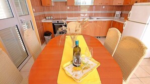 Un comedor con mesa de madera, mantel individual amarillo y sillas.