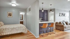 A compact living space with a bed, a kitchenette, and a seating area. - Crestview 55: Pet Friendly, Close to The Village (Mammoth Lakes)