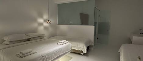Un dormitorio moderno con una cama grande, mesitas de noche y un espejo.